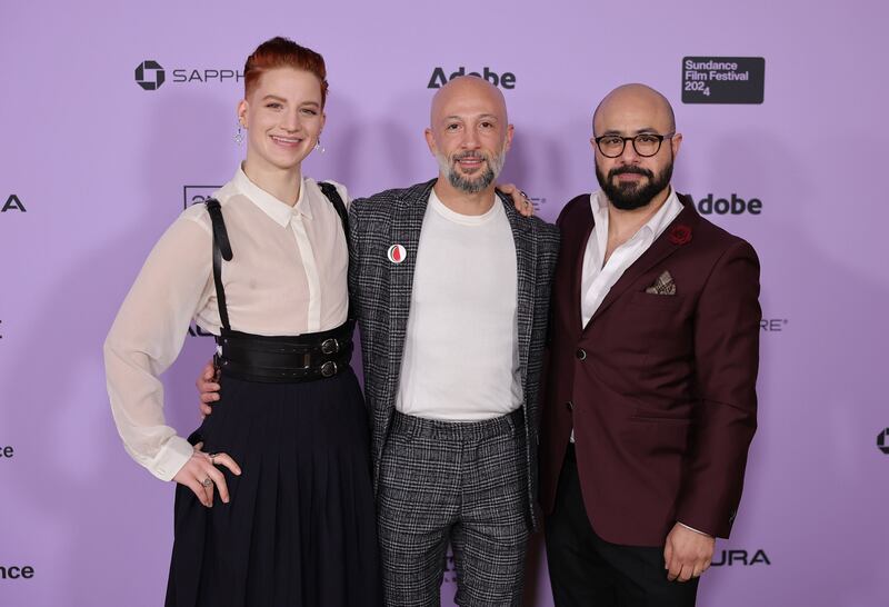 Theo Germaine, Director Jules Rosskam and Aden Hakimi pose for a photo in front of a step and repeat at the Sundance Film Festival