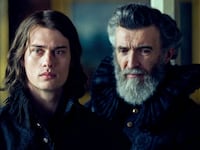 Nicholas Galitzine and Mark O’Halloran stand next to each other in a still from ‘George and Mary’