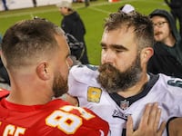 Philadelphia Eagles center Jason Kelce and Kansas City Chiefs tight end Travis Kelce hug after an NFL football game.