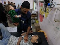 A man holds an injured child at the Al-Quds Hospital in Gaza.
