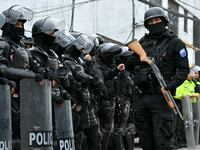 Police forces line up together in the street.
