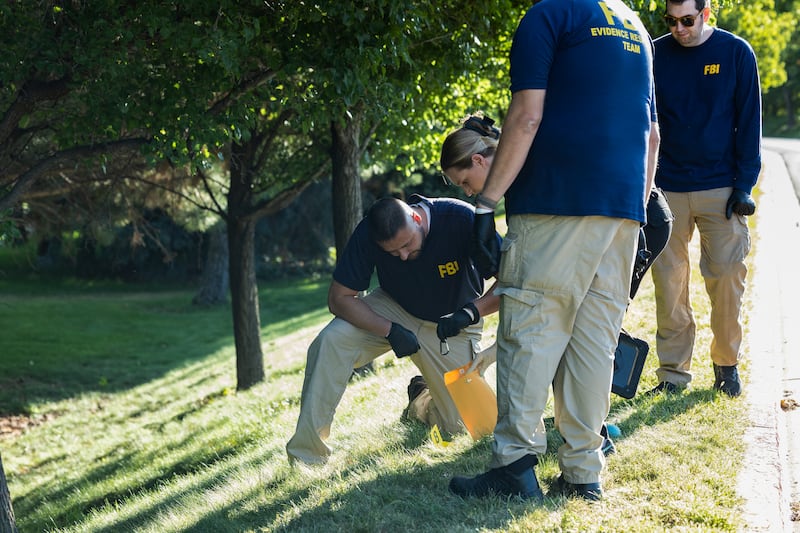 Law enforcement officials, including members of an FBI forensics team, investigate woods on September 11, 2025 near the crime scene where political activist Charlie Kirk was shot and killed at Utah Valley University in Orem, Utah, the day prior.