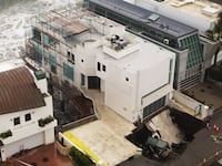 TOPSHOT - This aerial view shows a sinkhole on a street and driveway of a seaside home affected by large swells produced by Hurricane Marie in Malibu, California, on September 8, 2026. Hurricane Marie stayed well offshore of Southern California during Labor Day weekend but its large swells produced dangerous surf and rip currents, with waves reaching around 10 feet in some areas. (Photo by David Swanson / AFP via Getty Images)