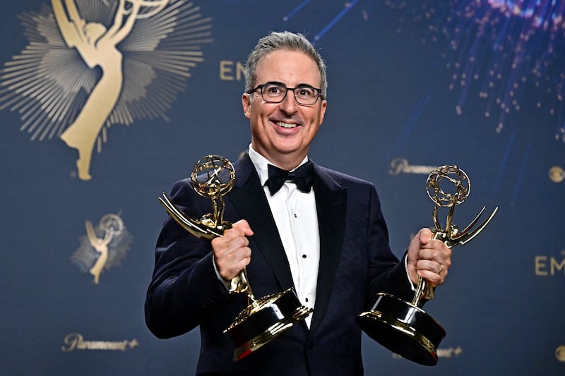 British television host John Oliver poses in the press room with the awards for Outstanding Writing for a Variety Series and Outstanding Scripted Variety Series award for "Last Week Tonight With John Oliver" during the 77th Primetime Emmy Awards at the Peacock Theatre at LA Live in Los Angeles on September 14, 2025. (Photo by Frederic J. Brown / AFP) / RESTRICTED TO EDITORIAL USE (Photo by FREDERIC J. BROWN/AFP via Getty Images)