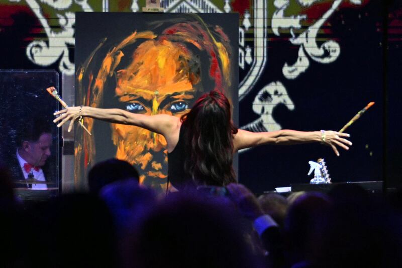 Christian speed artist Vanessa Horabuena paints a Jesus art piece during the New Year's Eve Party hosted by US President Donald Trump at his Mar-a-Lago residence in Palm Beach, Florida on December 31, 2025. (Photo by Jim WATSON / AFP via Getty Images)