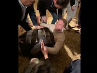 Connor Padgett yells at partygoers as they all struggle to get him out of a decorative urn.