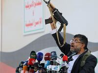 Mohammed Ali al-Houthi, a member of the Houthi supreme political council, speaks while holding a gun, as supporters of the Houthi movement rally to denounce air strikes launched by the U.S. and Britain on Houthi targets, in Sanaa, Yemen