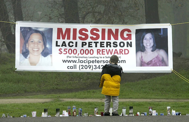 A sign displays photos of Laci Peterson along with a promised reward of $500,000.