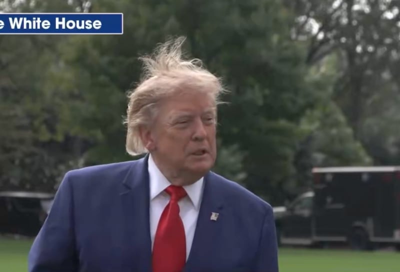Donald Trump's hair has a life of its own during a press gaggle on October 16.