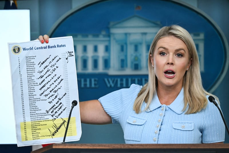 White House Press Secretary Karoline Leavitt, holding up a sheet showing global interest rates and a message from President Donald Trump to Federal Reserve Chair Jerome Powell, speaks during the daily briefing in the Brady Briefing Room of the White House in Washington, DC, on June 30, 2025.