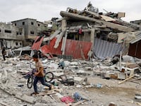 A child walks at the site of an Israeli air strike on a house in Gaza.