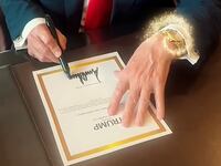 Donald Trump signs a certificate for a one of his Trump Watch endorsed products.
