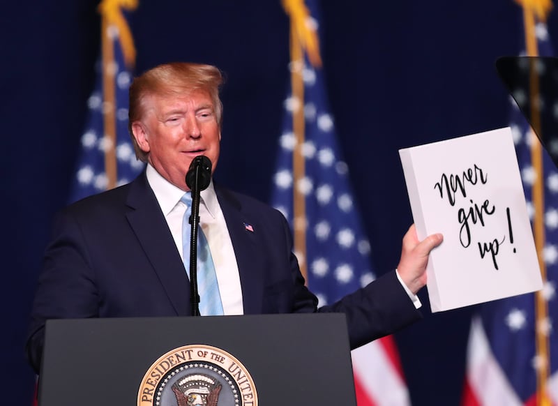 President Donald Trump holds up a sign during an 'Evangelicals for Trump' campaign event on January 3, 2020 in Miami, Florida.