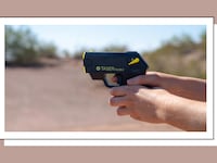 Hands holding a TASER Pulse 2 self-defense device