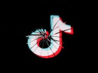 TikTok logo displayed on a phone screen is seen through the broken glass in this illustration photo taken in Krakow, Poland on April 24, 2024.
