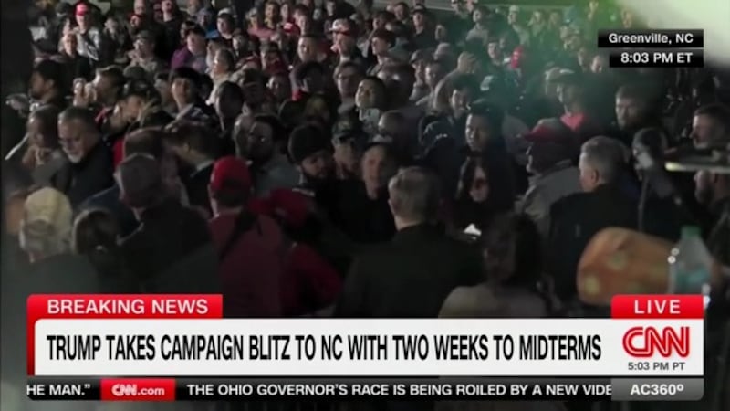 The protester is manhandled by security.