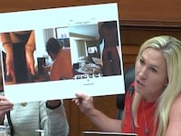Rep. Marjorie Taylor Greene showing several blown-up nude images of Hunter Biden.
