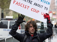 Maxwell Azzarello holds a sign that warns of a “fascist coup.”