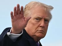 US President Donald Trump waves while boarding Air Force One at Palm Beach International Airport on November 30, 2025, on his way back to Washington, DC. President Trump and First Lady Melania Trump spent the Thanksgiving holiday at his Mar-a-Lago residence. (Photo by Jim WATSON / AFP via Getty Images)