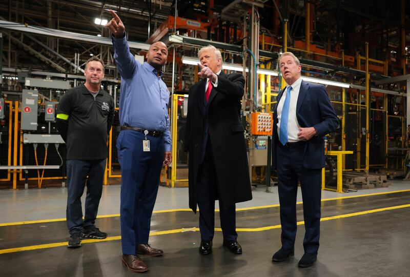 U.S. President Donald Trump (2R) talks with Ford River Rouge Plant Manager Corey Williams (2L), and Executive chair of Ford Motor Company Bill Ford Jr. (R) as they tour the Ford River Rouge Complex on January 13, 2026 in Dearborn, Michigan.