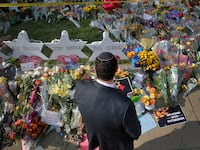 A man prays at a makeshift memorial outside the Tree of Life synagogue.