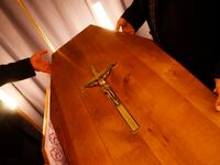 Regional funeral parlour employees place the lid on a coffin as they finish funeral preparations in Pessac, southwestern France.