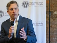Andy Ogles holds a microphone as he gives a speech