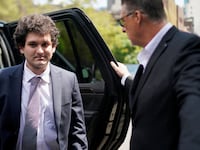 Sam Bankman-Fried exits a vehicle on his way into court.