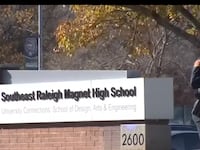 A police officer stands in front of South Raleigh High School