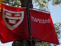 Banners for Harvard Law School fly during the inauguration of Lawrence Bacow as the 29th President of Harvard University in Cambridge