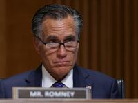 Mitt Romney stares forward during a committee hearing.