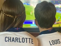Charlotte and Louis watch the football.