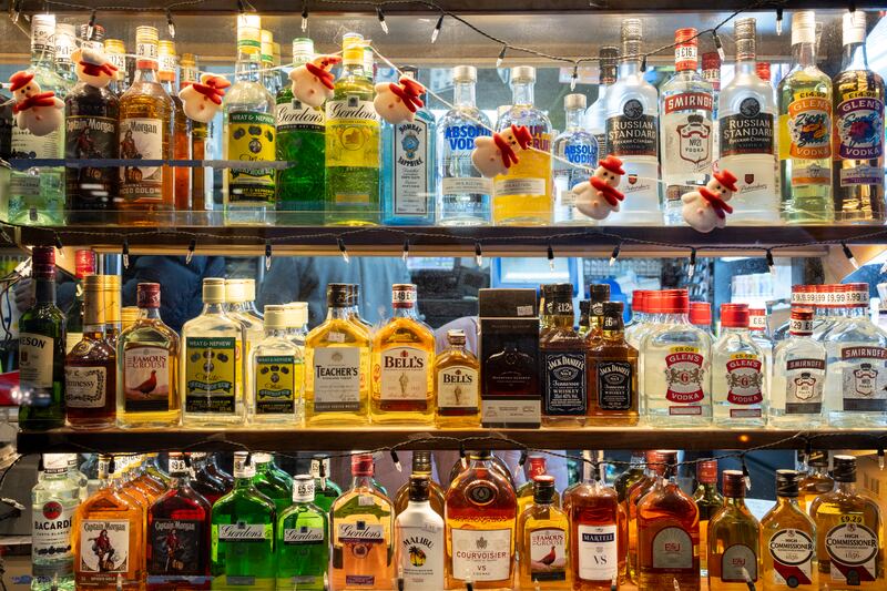 Liquor bottles lined up a store shelf.