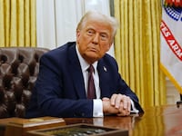 President Donald Trump speaks to reporters after signing a series of executive orders in the Oval Office of the White House on January 23.