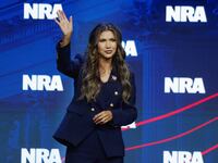 Kristi Noem waves to audience members at the 2023 National Rifle Association convention.
