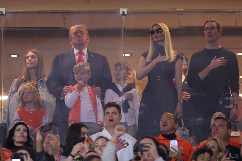 MIAMI GARDENS, FLORIDA - JANUARY 19: U.S. President Donald Trump stands for the National Anthem with his family prior to a game between the Miami Hurricanes and the Indiana Hoosiers in the 2026 College Football Playoff National Championship at Hard Rock Stadium on January 19, 2026 in Miami Gardens, Florida. (Photo by Alex Slitz/Getty Images)