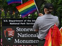 A National Park Service ranger places rainbow flags on the fence at the Stonewall National Monument in the West Village neighborhood of Greenwich Village in Lower Manhattan, New York City on June 19, 2019.