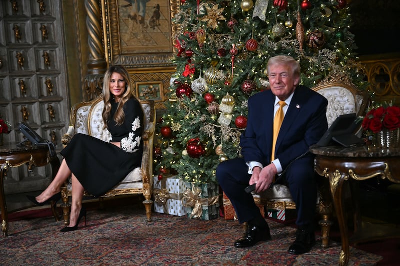 US President Donald Trump and first lady Melania Trump participate in NORAD Santa tracker phone calls, on Christmas Eve, from the Mar-a-lago club in Palm Beach, Florida, on December 24, 2025. (Photo by ANDREW CABALLERO-REYNOLDS / AFP via Getty Images)