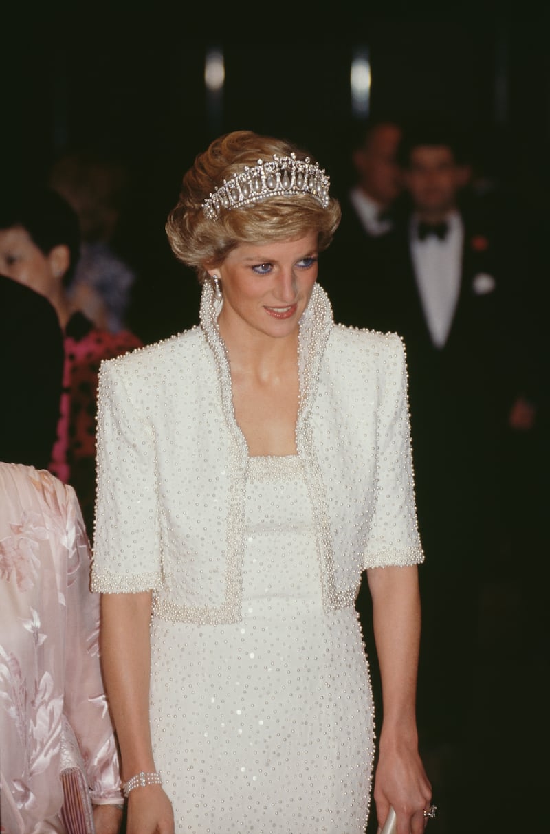Diana, Princess of Wales, attends the 1989 gala opening of a cultural center in Hong Kong, wearing a white beaded evening gown by Catherine Walker.