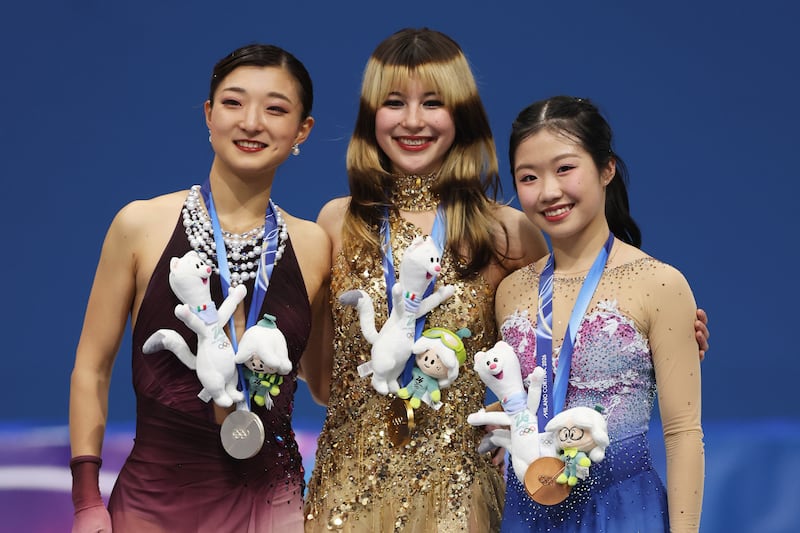 Gold medalist Alysa Liu of Team United States, silver medalist Kaori Sakamoto of Team Japan, and bronze medalist Ami Nakai of Team Japan pose for a photo on the podium during the medal ceremony for the Women's Single Skating on day 13 of the Milano Cortina 2026 Winter Olympic Games at Milano Ice Skating Arena on February 19, 2026.