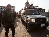 Members of an Iraqi Shi'ite armed group sit in a vehicle after an attack by a drone strike on an Iran-backed militia headquarters in Baghdad, Iraq January 4, 2024.