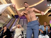 A photo of Carl Radke taking off his shirt at BravoCon