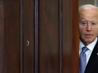 President Biden peeks out from behind a door before delivering remarks at the White House.