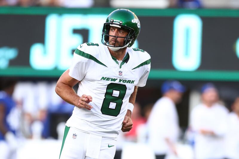 Aaron Rodgers #8 of the New York Jets reacts after throwing a first quarter touchdown pass to Garrett Wilson #17 in a preseason game against the New York Giants at MetLife Stadium on August 26, 2023 in East Rutherford, New Jersey.
