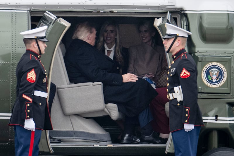 President Donald Trump speaks with White House Press Secretary Katie Zacharia and aide Natalie Harp after boarding Marine One at Elmendorf Air Force Base in Anchorage, Alaska, on October 13, 2026.