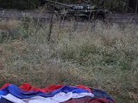 A Russian national flag lies on the ground near a destroyed Russian tank in the town of Izium, Ukraine, on Sept. 14, 2022.