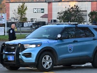 Police stand near the recycling plant where the body of suspected mass shooter Robert Card was found in Lisbon Falls, Maine.
